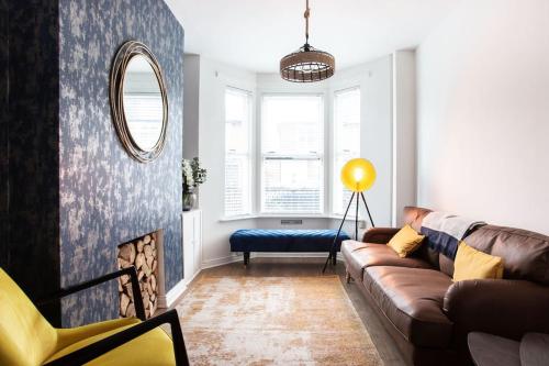 a living room with a couch and a mirror at Luxurious 4-Bed Townhouse in the Heart of Belfast in Belfast