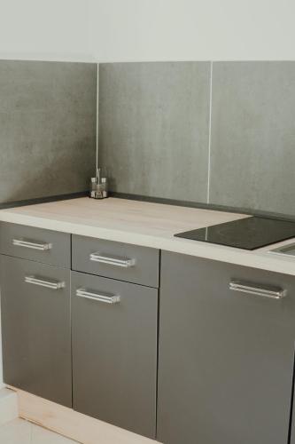a kitchen with white cabinets and a white counter top at Apartmán EMILY in Brezno
