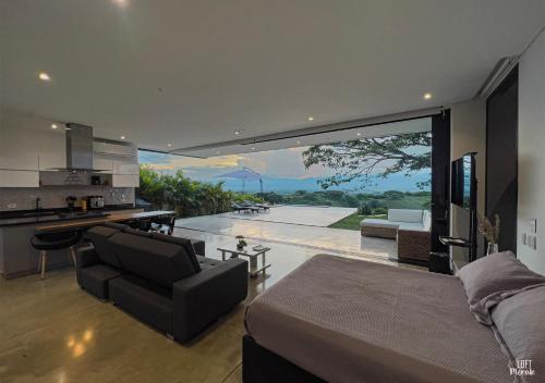 uma cozinha e sala de estar com uma grande janela de vidro em LoftMerak em Pereira