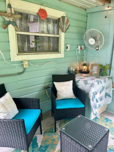 a patio with two chairs and a table and a window at Cocoa, Beach house in Cocoa