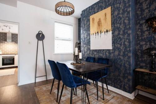 a dining room with a table and blue chairs at Luxurious 4-Bed Townhouse in the Heart of Belfast in Belfast