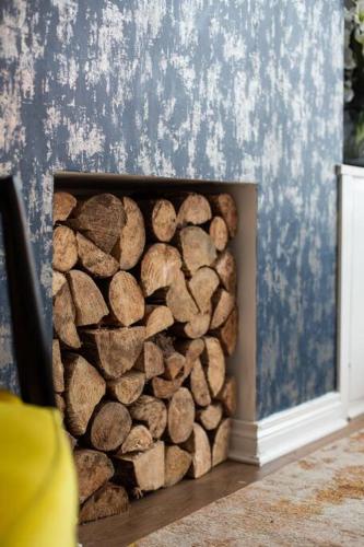 a pile of logs in a corner of a wall at Luxurious 4-Bed Townhouse in the Heart of Belfast in Belfast