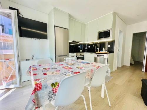 a kitchen with a table with white chairs and a dining room at Âncora - Beach 50m - Sea View Terrace in Armação de Pêra