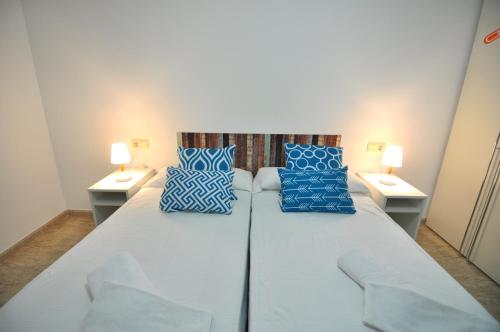 エンプリアブラバにあるRNET - BCel Empuriabravaの白い大型ベッド(青い枕、ランプ2つ付)
