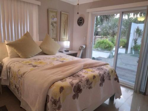 een slaapkamer met een bed en een glazen schuifdeur bij Naples' Hidden Gem in Naples