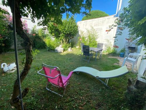 un groupe de chaises et une table dans une cour dans l'établissement Maison de vacances 4 étoiles, à Saint-Georges-de-Didonne