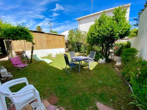 une cour avec des chaises, une table et une clôture dans l'établissement Maison de vacances 4 étoiles, à Saint-Georges-de-Didonne