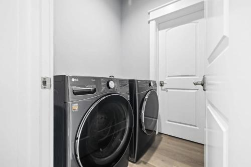 a washing machine in a laundry room with a door at Scissortail at Treetop in Santa Rosa Beach