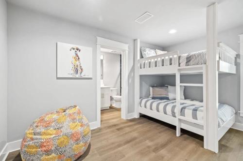 a room with two bunk beds and a chair at Scissortail at Treetop in Santa Rosa Beach