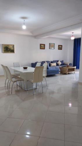ein Wohnzimmer mit einem Tisch, Stühlen und einem Sofa in der Unterkunft Tuleb bich in Tangier