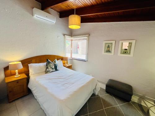 1 dormitorio con 1 cama y 1 silla en San Lameer Villa 2112, en Southbroom