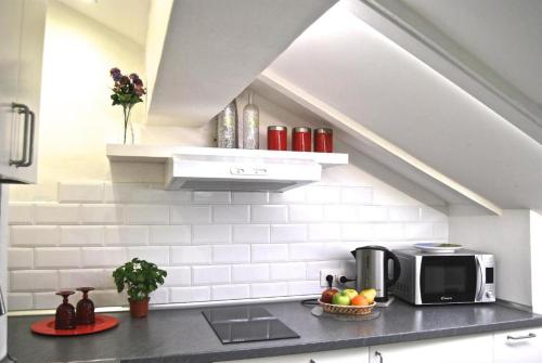 a kitchen with a microwave and fruits on a counter at Tourist House Bologna - Self check-in in Bologna