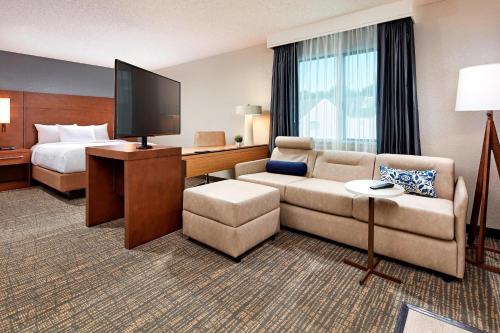 a hotel room with a couch and a bed and a television at Residence Inn Los Angeles LAX/Manhattan Beach in Manhattan Beach