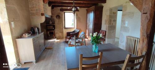 une cuisine avec une table avec un vase de fleurs dessus dans l'établissement La Croisée, à Causse et Diege