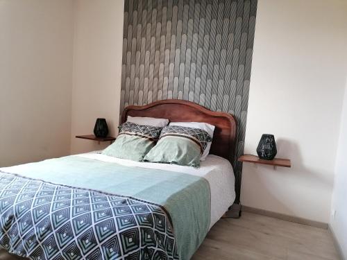 1 dormitorio con 1 cama con cabecero de madera en La Croisée, en Causse et Diege