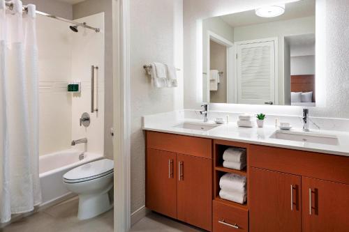 a bathroom with a sink and a toilet and a mirror at Residence Inn Los Angeles LAX/Manhattan Beach in Manhattan Beach