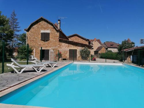 une grande piscine devant une maison dans l'établissement La Croisée, à Causse et Diege