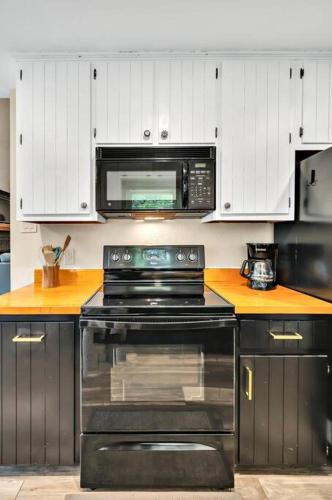 a kitchen with a stove and a microwave at New Cozy Retreat Located 15 minutes to Waco in Hewitt