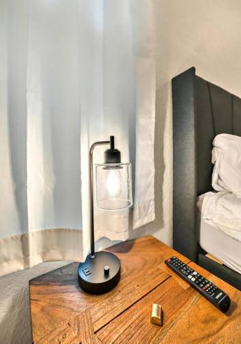 a lamp on a wooden table next to a bed at New Cozy Retreat Located 15 minutes to Waco in Hewitt