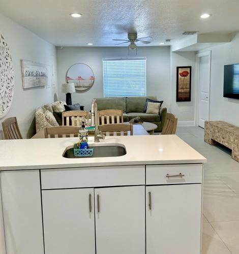 a kitchen with a sink and a living room at Close to everything! Perfect basecamp for WPB in West Palm Beach