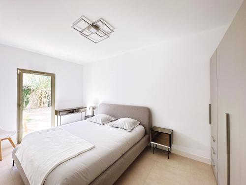 a white bedroom with a bed and a window at Appartement Moderne tout équipé. in Marseille