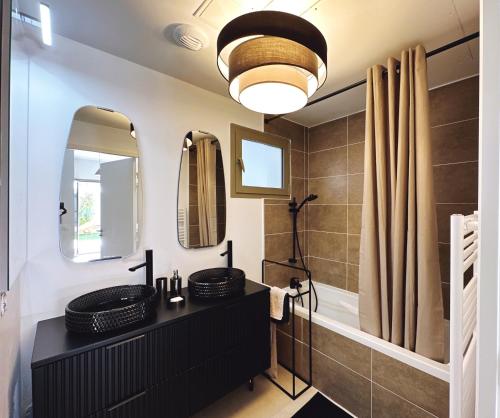 La salle de bains est pourvue de 2 lavabos et de 2 miroirs. dans l'établissement Appartement Moderne tout équipé., à Marseille