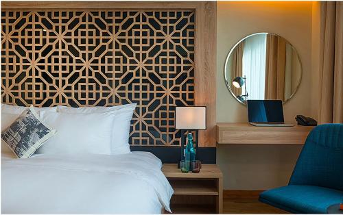 a bedroom with a bed and a mirror and a chair at Gemini Saigon LUXURY in Ho Chi Minh City