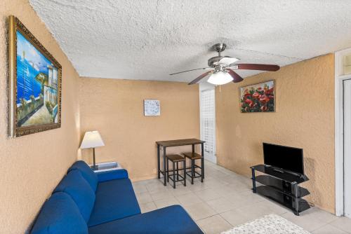 un soggiorno con divano blu e ventilatore a soffitto di One Nice Caribbean View condo a Christiansted