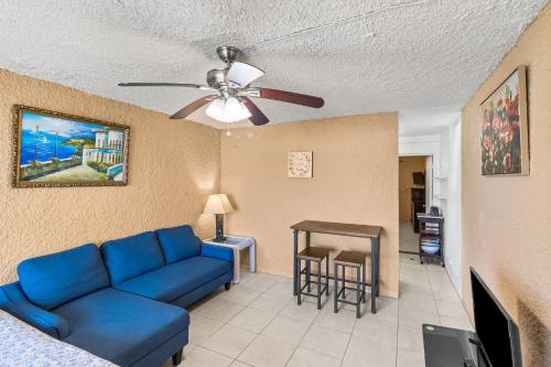 een woonkamer met een blauwe bank en een plafondventilator bij One Nice Caribbean View condo in Christiansted
