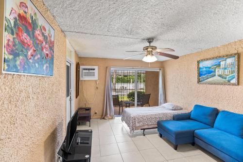 un soggiorno con un divano blu e un letto di One Nice Caribbean View condo a Christiansted
