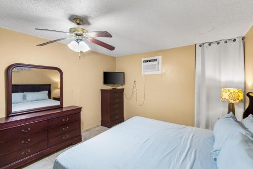 a bedroom with a bed and a mirror and a ceiling fan at Caribbean home with a view condo in Christiansted