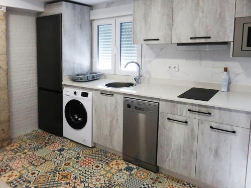 蓬塔翁布里亞的住宿－Apartamento frente al mar，厨房配有水槽和洗衣机