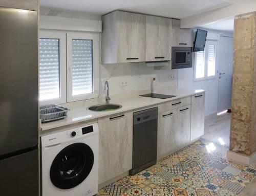 蓬塔翁布里亞的住宿－Apartamento frente al mar，厨房配有洗衣机和水槽