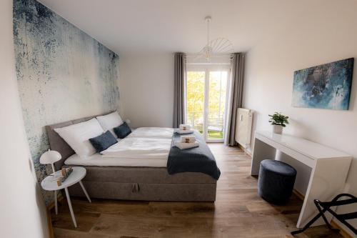 a small bedroom with a bed and a desk at Come4Stay Passau - GubyBlue & GubySun - 2 Wohnungen I bis zu 7 Gäste in Passau