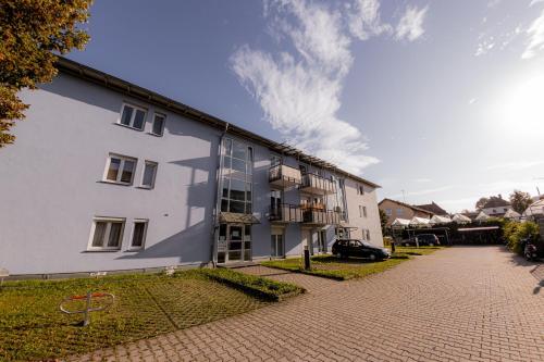 a large white building on a brick street at Come4Stay Passau - GubyBlue & GubySun - 2 Wohnungen I bis zu 7 Gäste in Passau
