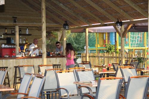 a group of tables and chairs in a restaurant at Olympion Village Studios in Zakharo