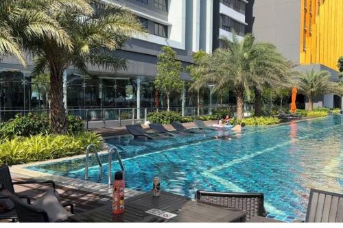 een groot zwembad met stoelen en een gebouw bij D' Residensy Homestay in Kuala Lumpur