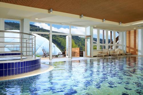 a large swimming pool with a view of a mountain at OREA Resort Sklář Harrachov in Harrachov