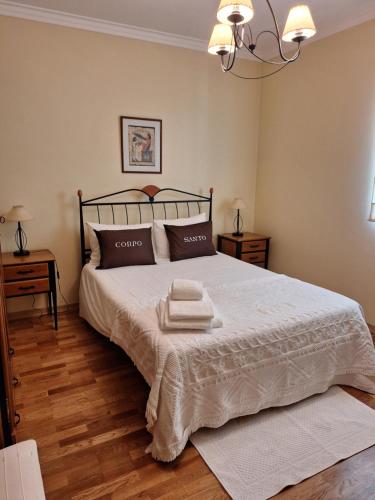 ein Schlafzimmer mit einem Bett mit zwei Handtüchern darauf in der Unterkunft B House Verdizela in Corroios