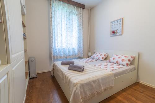 een slaapkamer met een bed met 2 kussens erop bij Cozy Central Condo with Free Dedicated Parking in Sofia