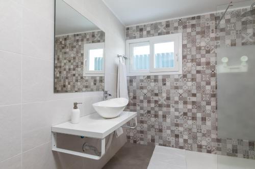 Baño blanco con lavabo y espejo en Magnifico Chalet en Montesano, en San Antonio de Benagéber
