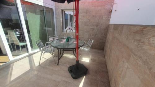 a table with chairs and an umbrella in a room at HyP - A Casa da Fina in Miño