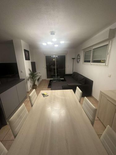 sala de estar con mesa de madera y sofá en Appartement T3 meublé pour un séjour en toute tranquillité en Perpiñán