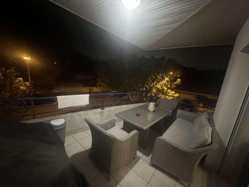 una mesa y sillas en un balcón por la noche en Appartement T3 meublé pour un séjour en toute tranquillité en Perpiñán