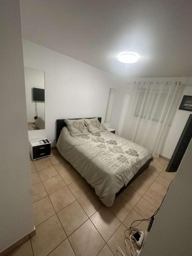 1 dormitorio con 1 cama y suelo de baldosa en Appartement T3 meublé pour un séjour en toute tranquillité en Perpiñán