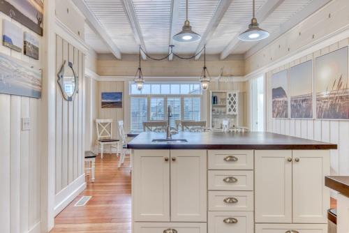 a kitchen with white cabinets and a large island at Oceans Away in Seaside