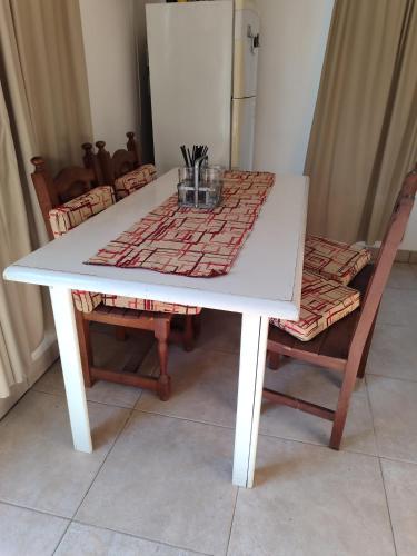 einen weißen Tisch mit 2 Stühlen und einen Kühlschrank in der Unterkunft Depto Oro Verde in Oro Verde