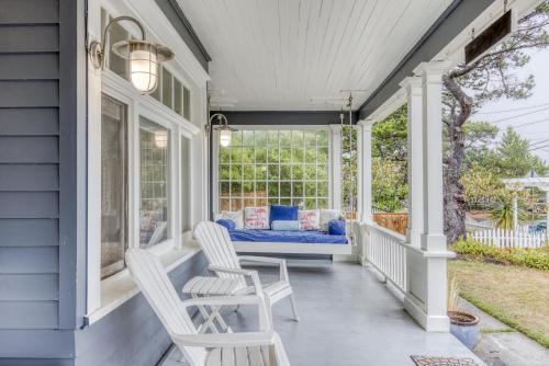 a porch with two white chairs and a blue couch at Oceans Away in Seaside