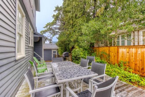 a patio with a table and chairs and a fence at Oceans Away in Seaside