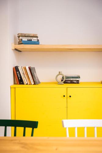 a yellow cabinet with a shelf and books at Resort po.spolu in Mokrovraty